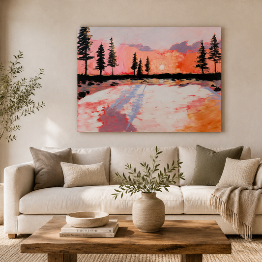 A colorful landscape painting of a sunset over a field with pine trees, displayed on a beige wall above a modern white sofa in a styled living room.